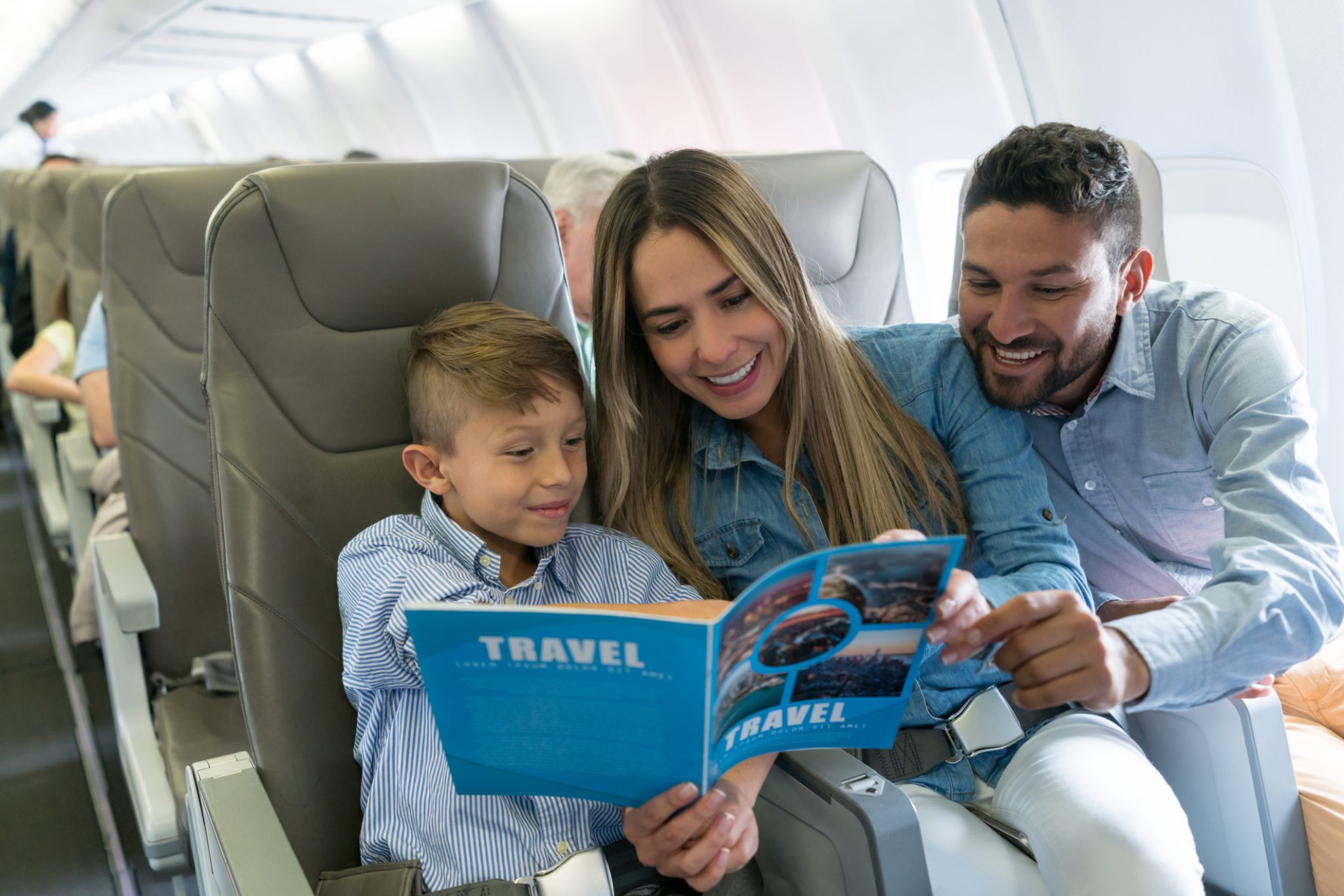 Mum and dad reading to their child on a plane