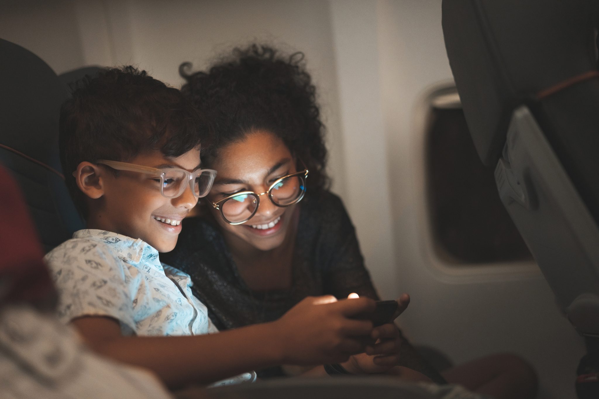 Mother and child looking at a screen on the plane