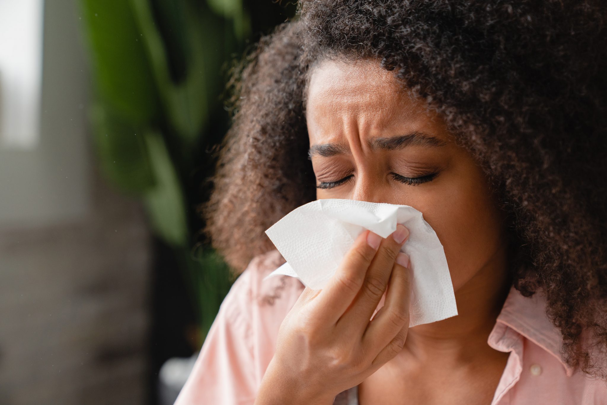 Woman with hay fever, using a tissue